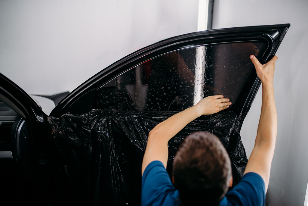 technician adding tint to the passenger side window